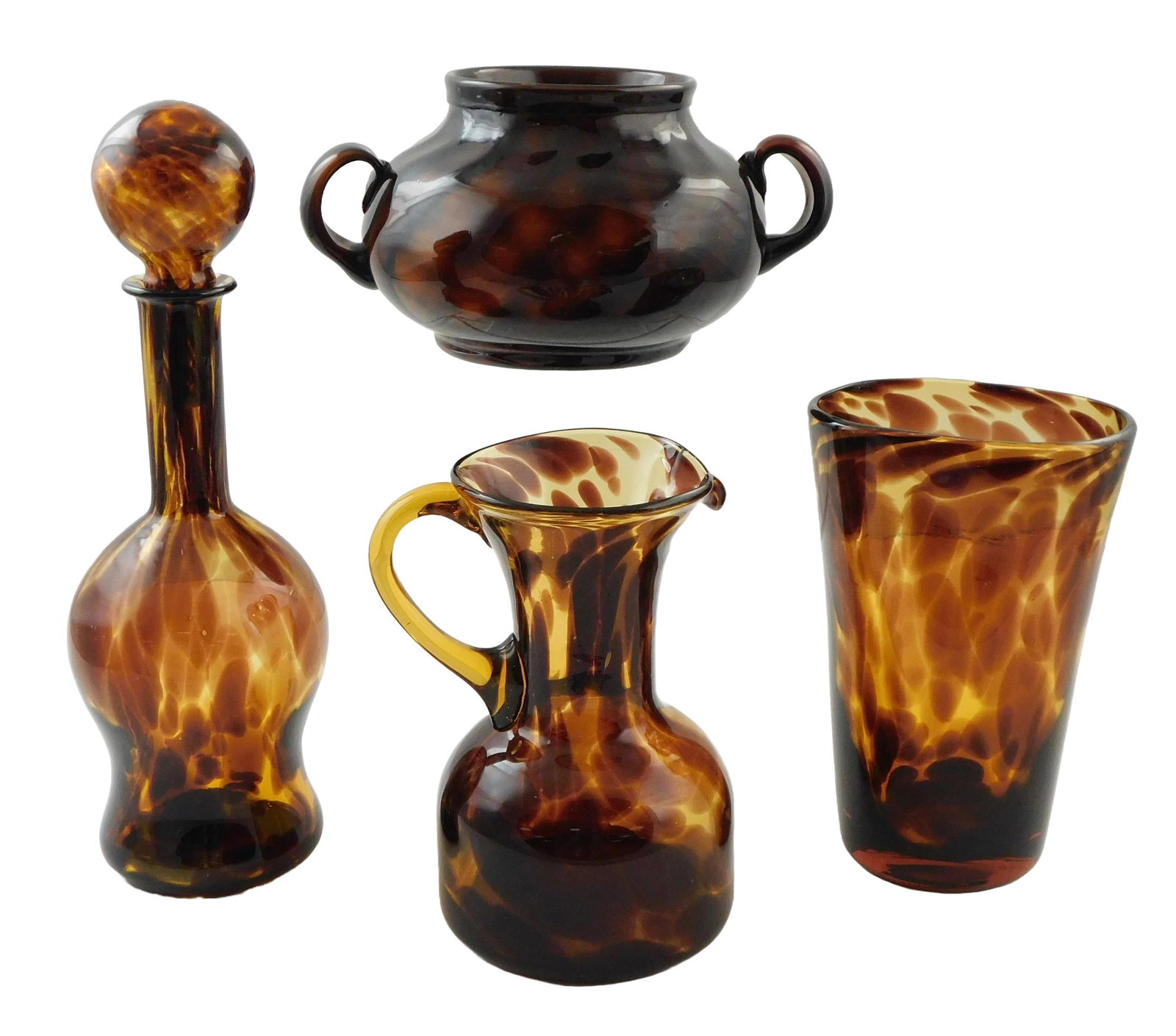 GLASS: Four pieces of tortoiseshell glass, including: pitcher with wide base and applied handle, 7: GLASS: Four pieces of tortoiseshell glass, including: pitcher with wide base and applied handle, 7 5/8” h.; vase with flattened sides making opening slightly ovoid, 8” h.; decanter with bl