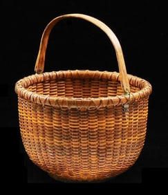 Nantucket basket, bentwood swing handle, round with domed base, discoloration on base suggests a