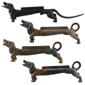 Four Dachshund cast iron boot scrapers, unmarked, three with pink painted tongue and loop tails, one