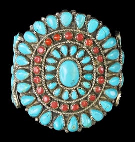 JEWELRY: Large silver Zuni cuff bracelet with turquoise and coral stones, flower form center