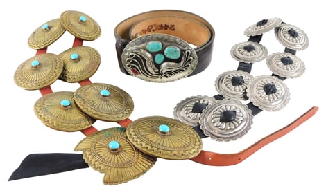 Three Southwest style leather belts, one with a pewter buckle, one with brass concho medallions, and