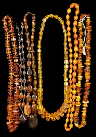 JEWELRY: Six amber or amber type necklaces, three on hand knotted strands, two with pendants, one