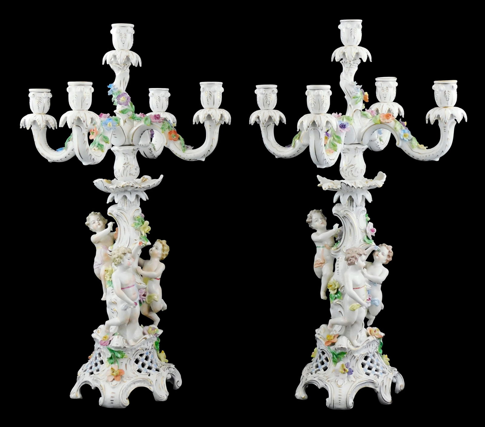 Pair of Dresden porcelain five-light candelabra, early 20th C., attributed to the Carl Thieme Saxoni: Pair of Dresden porcelain five-light candelabra, early 20th C., attributed to the Carl Thieme Saxonian Porcelain Factory, Rococo style featuring three putti among floral designs on gilt scrolling and