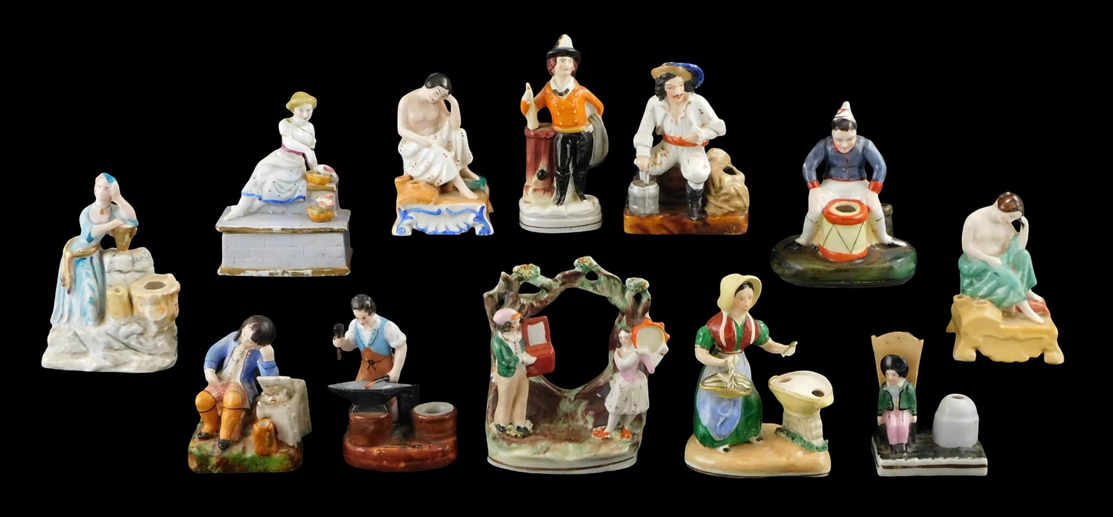 Staffordshire, etc., group of twelve figures and inkwells, 19th/ early 20th C., one box, two figurin: Staffordshire, etc., group of twelve figures and inkwells, 19th/ early 20th C., one box, two figurines, nine inkwells, details include: a blacksmith, firefighter, "Will Watch" pirate figure, pair of m