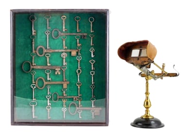 Stereopticon viewer and skeleton key display, details include: stereopticon viewer on brass and cast