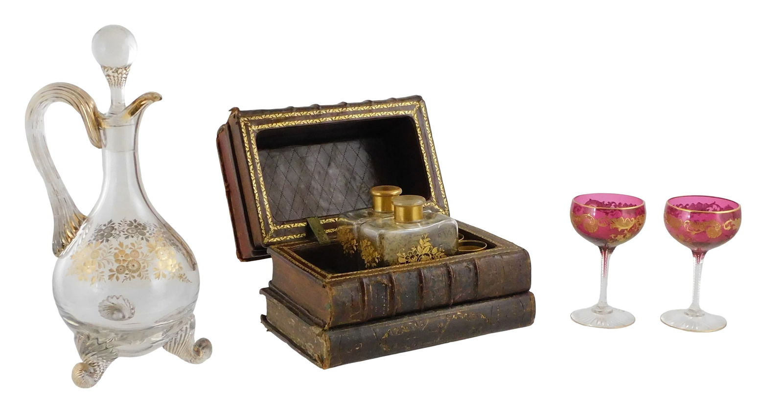 Leather book tantalus decanter set with larger decanter and other glass, early 20th C., details incl: Leather book tantalus decanter set with larger decanter and other glass, early 20th C., details include: leather book tantalus that opens to two decanters and two small glasses, book case with damages