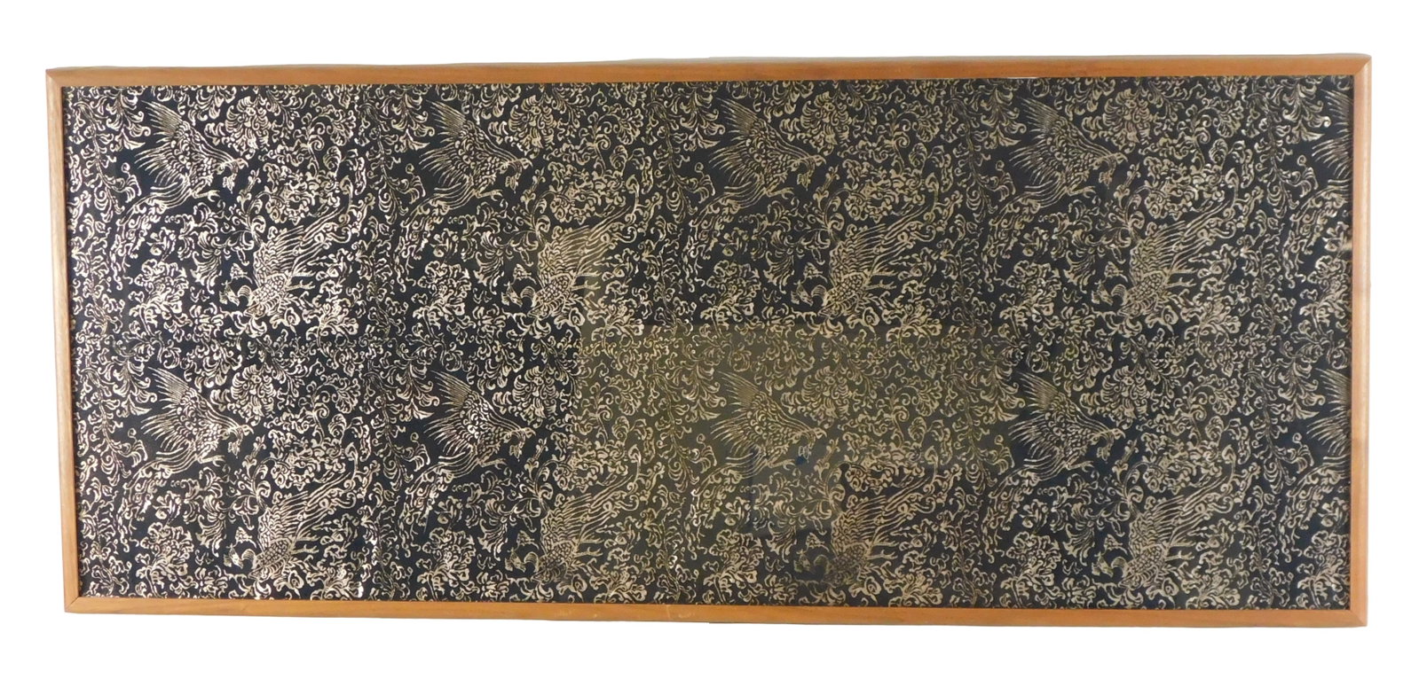 ASIAN: Woven textile in gold metallic thread on black ground, repeating phoenix decoration ensconced: ASIAN: Woven textile in gold metallic thread on black ground, repeating phoenix decoration ensconced by foliate scrolling vines, wear consistent with age and use, frame dimensions: 53 1/2" h. x 22 3/4