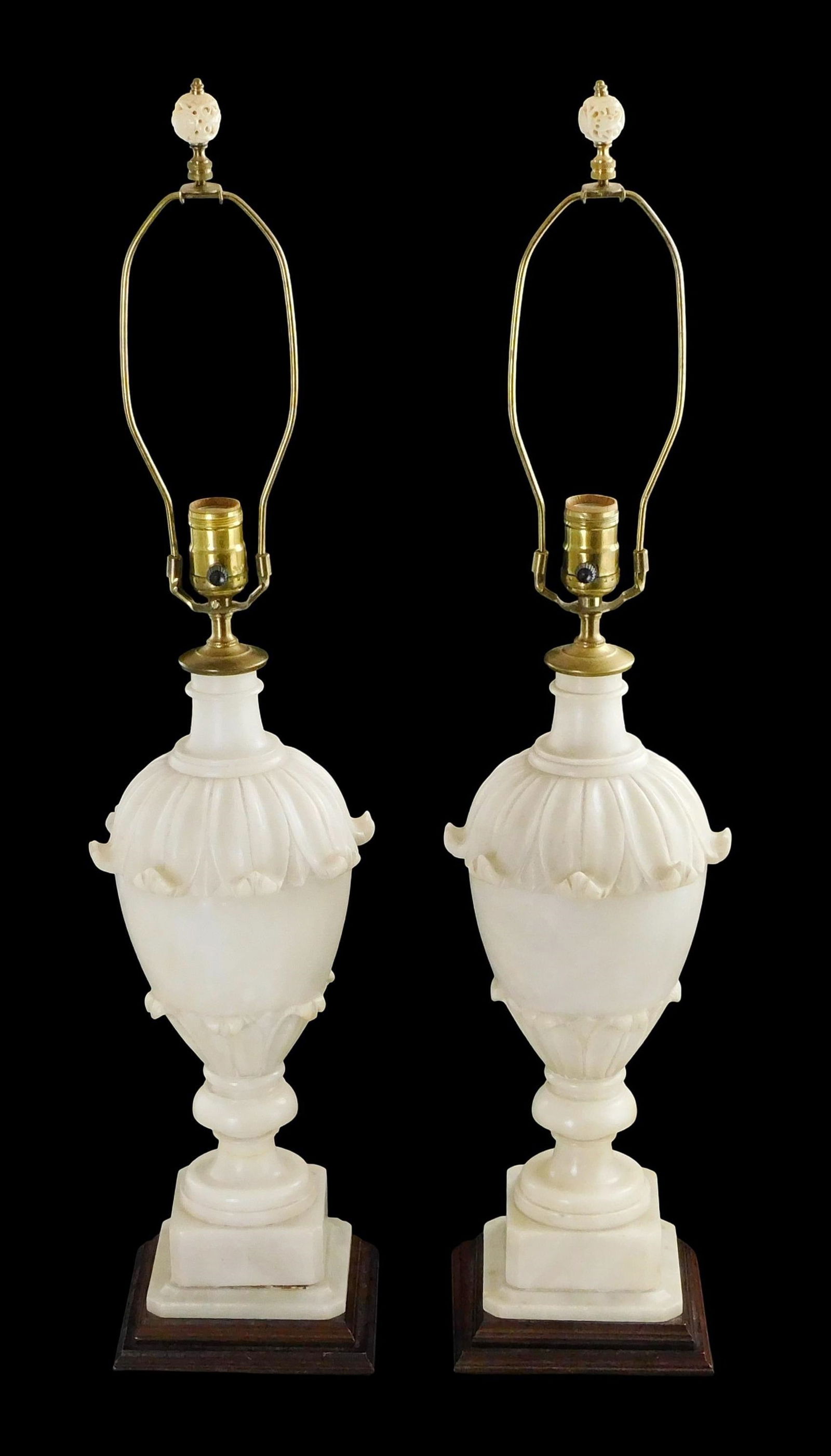 Pair of alabaster lamps, classical urn design with carved scrolling leaf motif, raised on ringed and: Pair of alabaster lamps, classical urn design with carved scrolling leaf motif, raised on ringed and square pedestal plinths, attached to wood bases, with harps featuring pierced bone finials, unknown