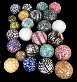 +Twenty-five pottery carpet balls, various sizes, colors, and designs, wear consistent with age and