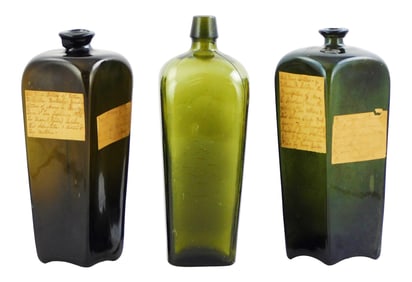 EARLY GLASS: Mid-19th C. case gin bottles with crude pontil marks and paper labels, three total, one
