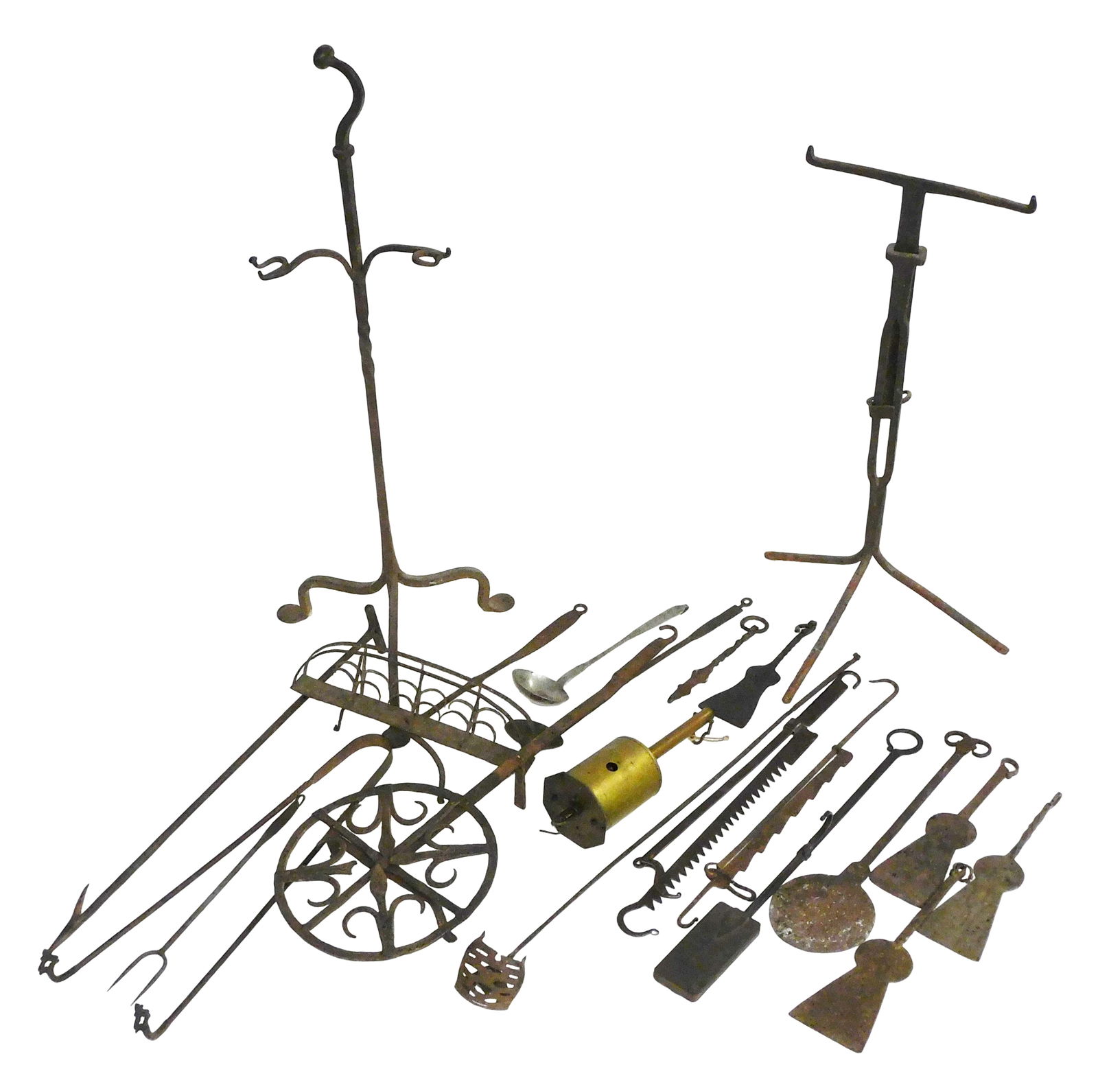 Early wrought iron and brass fireplace tools and accessories, twenty pieces total, including: two: Early wrought iron and brass fireplace tools and accessories, twenty pieces total, including: two stands with hooks, brass roasting spit jack, large trivet, toaster with swivel handle, various spoons,