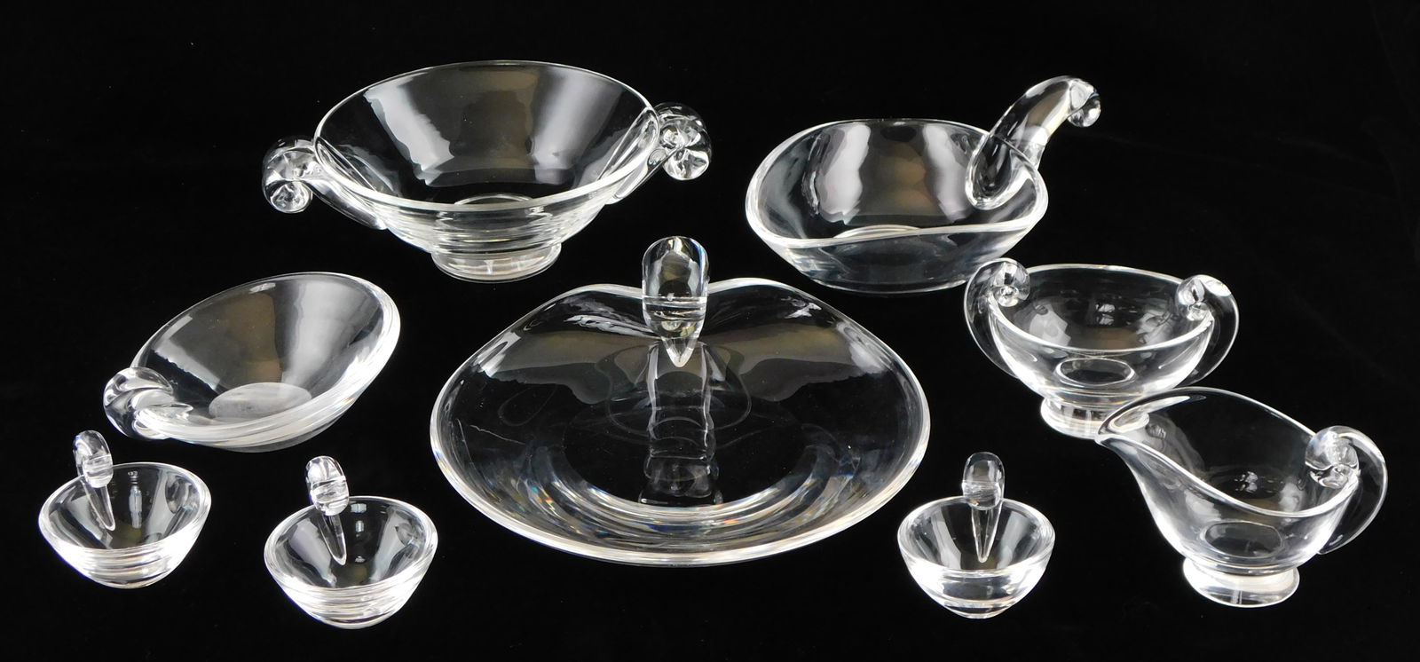 GLASS: Steuben crystal servingware, nine pieces with stylized scroll handle, all signed, including:: GLASS: Steuben crystal servingware, nine pieces with stylized scroll handle, all signed, including: bowl on tapered foot with flanking handles; leaf form bowl; small round bowl with slanted rim; round