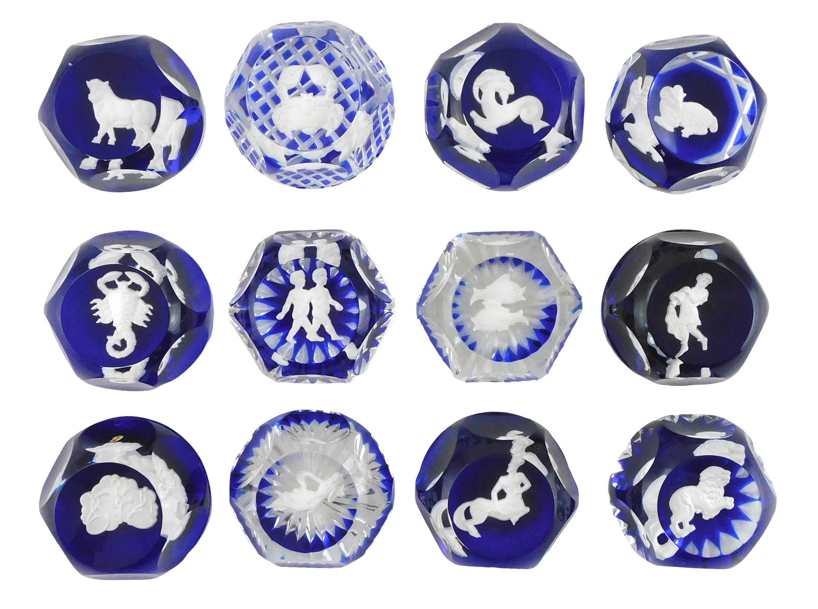 ART GLASS: Twelve Baccarat Zodiac sulfide paperweights, 20th C., France, all with makers mark, clear: ART GLASS: Twelve Baccarat Zodiac sulfide paperweights, 20th C., France, all with makers mark, clear orbs, top facet, six side facets, all on blue ground, depicting the twelve stages of zodiac in susp