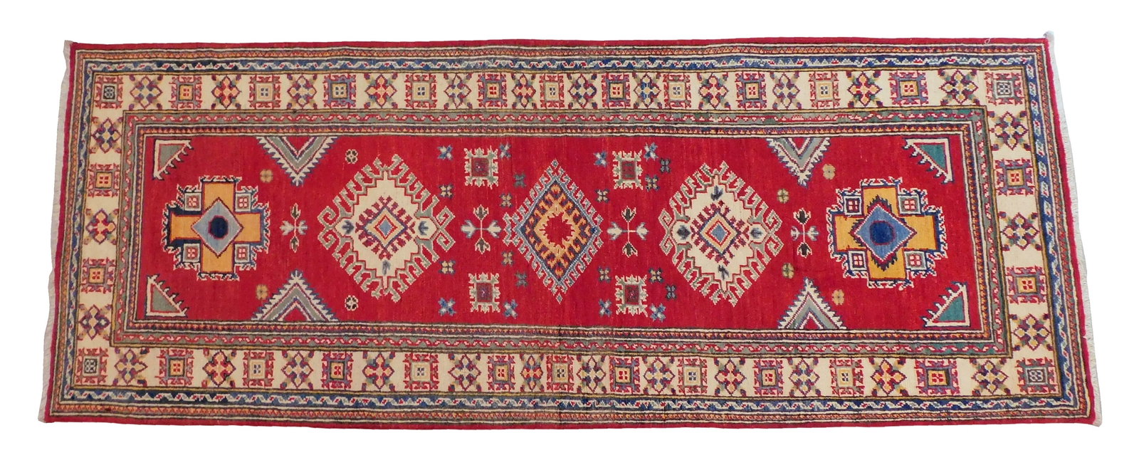 RUG: Uzbek Kazak runner, 3' x 7' 8", wool on cotton, red ground cream border, classic motifs, wear: RUG: Uzbek Kazak runner, 3' x 7' 8", wool on cotton, red ground cream border, classic motifs, wear consistent with age and use.