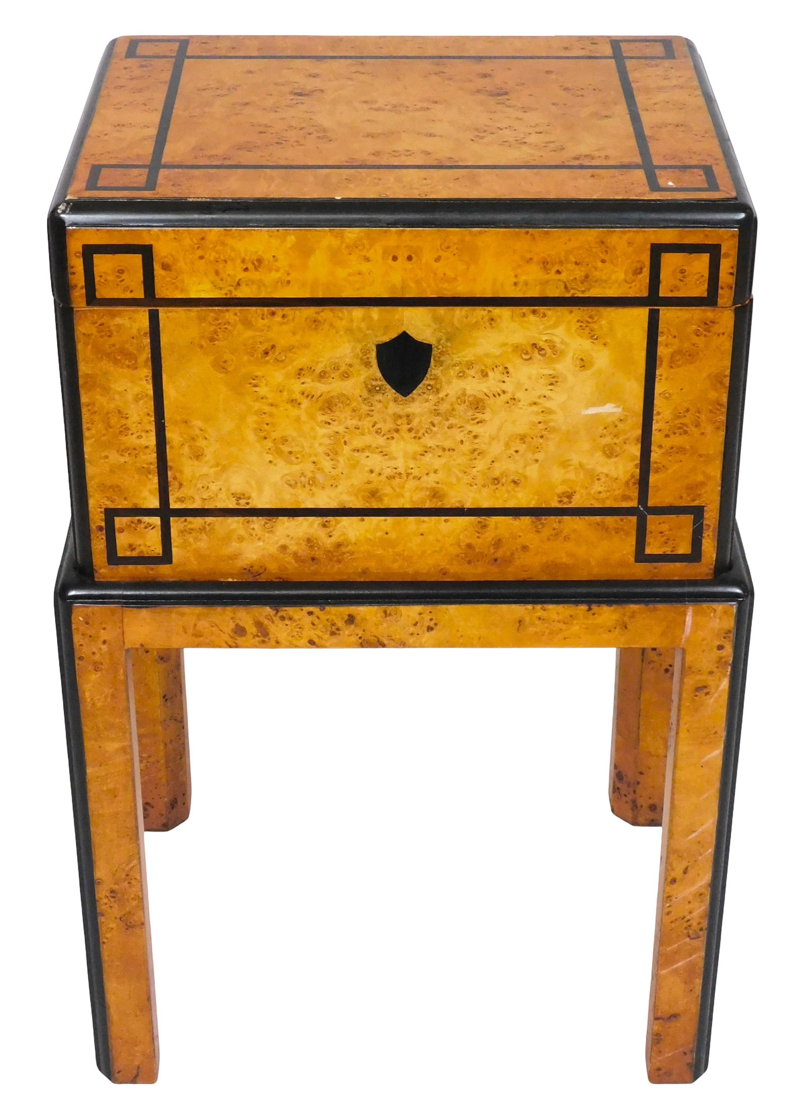 Burl wood and ebony box and attached stand, 20th C., hinge top box, burl veneer, inlaid ebony: Burl wood and ebony box and attached stand, 20th C., hinge top box, burl veneer, inlaid ebony parquetry, inlaid crest emblem to front, decorative brass handles to side, fixed atop four-legged stand, w