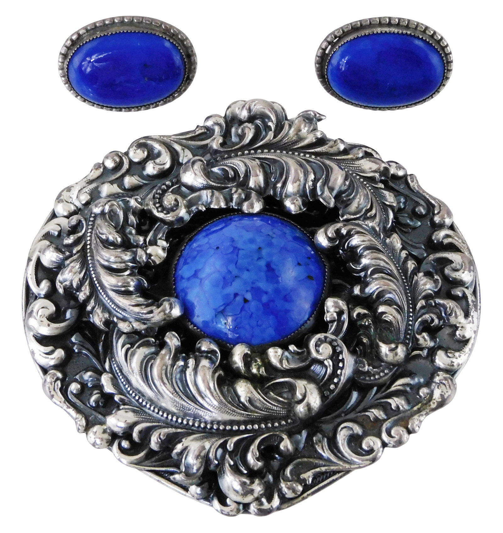 JEWELRY: Large ornately scrolled pin/pendant in tested silver, central glass cabochon, along with a (1 of 3)