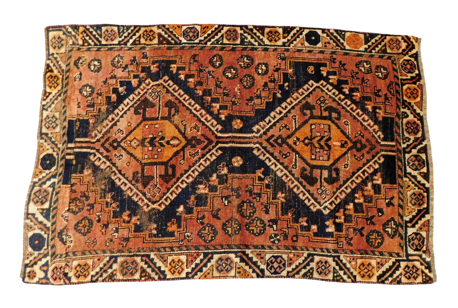 RUG: Quashqai rug, 4' x 5' 9", wool on wool, geometric design, two central medallions, rust ground,: RUG: Quashqai rug, 4' x 5' 9", wool on wool, geometric design, two central medallions, rust ground, cream border, accents of navy, orange and brown, wear consistent with age and use.