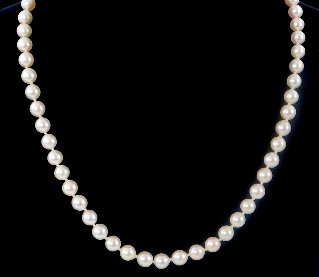 JEWELRY: Cultured pearl necklace with 14K gold clasp, fifty-nine round Akoya pearls, all 6.5 mm to 7: JEWELRY: Cultured pearl necklace with 14K gold clasp, fifty-nine round Akoya pearls, all 6.5 mm to 7 mm in size, oval hook clasp stamped and tested, pearls white with slight rose overtones, moderate-h