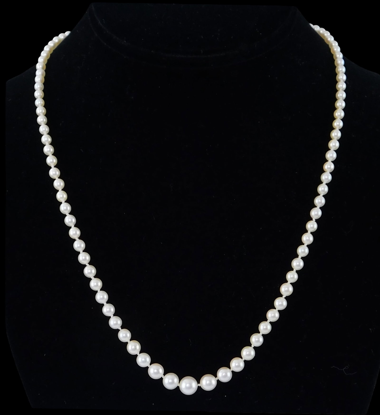 JEWELRY: Graduated pearl strand necklace, consisting of ninety-nine cultured pearls, 3.5mm-7.0mm;: JEWELRY: Graduated pearl strand necklace, consisting of ninety-nine cultured pearls, 3.5mm-7.0mm; slightly off-white with medium luster, with marquise shape clasp stamped and tested 14K white gold wit