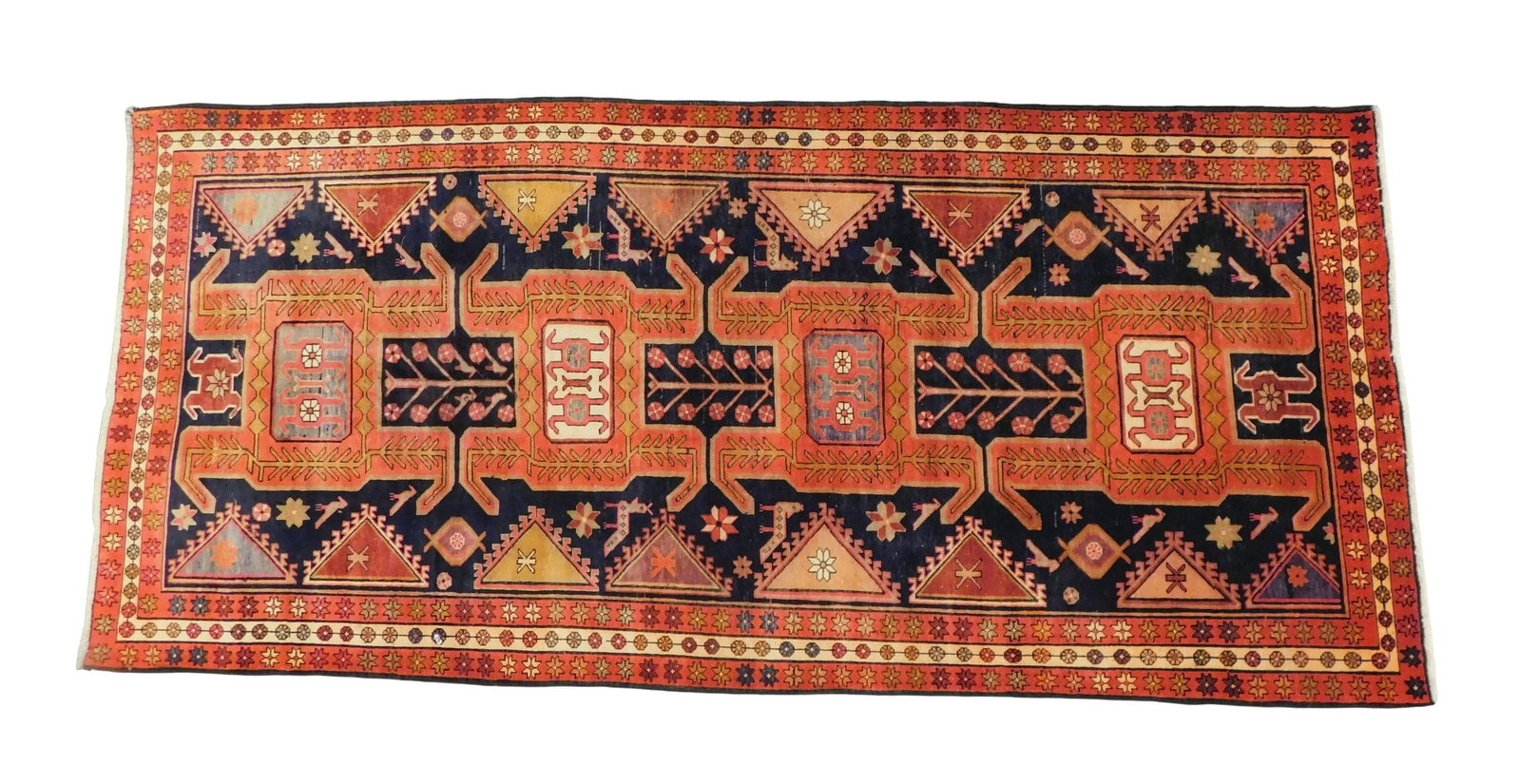 RUG: Semi-antique Northwest Persian, 5' x 10' 7", dark blue ground, red twin minor borders, classic: RUG: Semi-antique Northwest Persian, 5' x 10' 7", dark blue ground, red twin minor borders, classic tribal designs in tones of red, blue and orange, wear consistent with age and use.