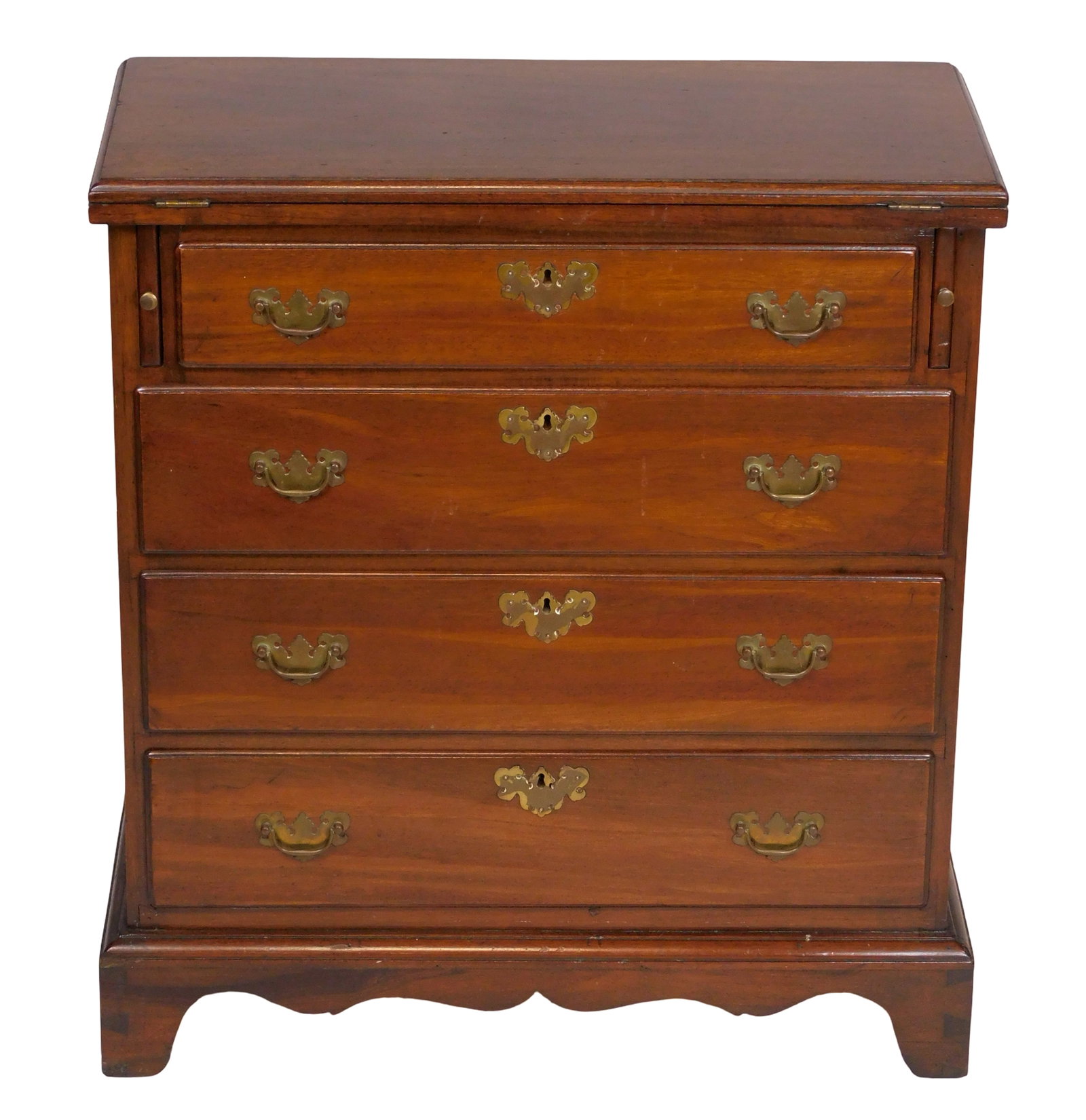 Diminutive chest of drawers, 19th C., likely English, mahogany and oak, hinged top opens onto: Diminutive chest of drawers, 19th C., likely English, mahogany and oak, hinged top opens onto lopers, over four long drawers, all on bracket base, curved front apron, wear consistent with age and use,
