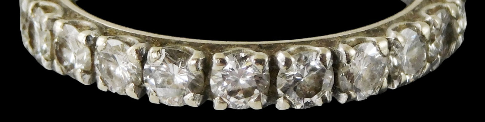 JEWELRY: 14K White gold and diamond eternity band, tested, four-prong settings, set with twenty-one: JEWELRY: 14K White gold and diamond eternity band, tested, four-prong settings, set with twenty-one round brillant cut diamonds, approcimate total weight: 2.10 ct., color: H-J, clarity: SI, one diamon