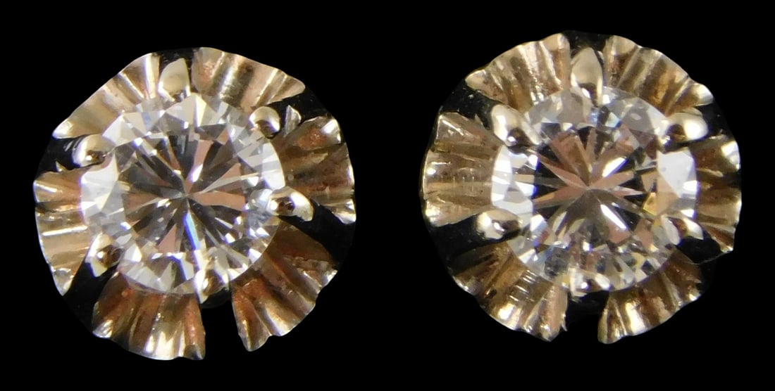 JEWELRY: Pair of 14K and diamond stud earrings, stamped and tested white gold six-prong illusion: JEWELRY: Pair of 14K and diamond stud earrings, stamped and tested white gold six-prong illusion crowns with friction post backs and base metal ear nuts, each set with one round brilliant cut natural 