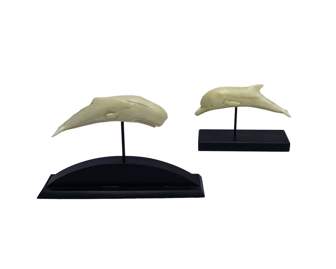 Two Carvings, Attributed to Charles Sayle: Both with beautiful patina of bone, both mounted on contemporary Ebony stands, dolphin with stand, 4.25” H x 5.5” W x 2” D sperm whale, 4.75” H x 7.5” W x 2” D Charles Sayles (1908-1994)