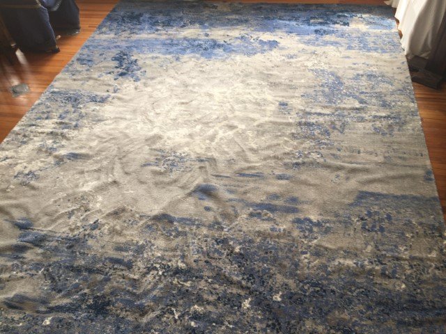 Area Rug: Blue/Beige Area Rug 12x15, After we laid it out for a few days, it smoothed out. It was rolled up after having it cleaned and stayed that way for a long while.