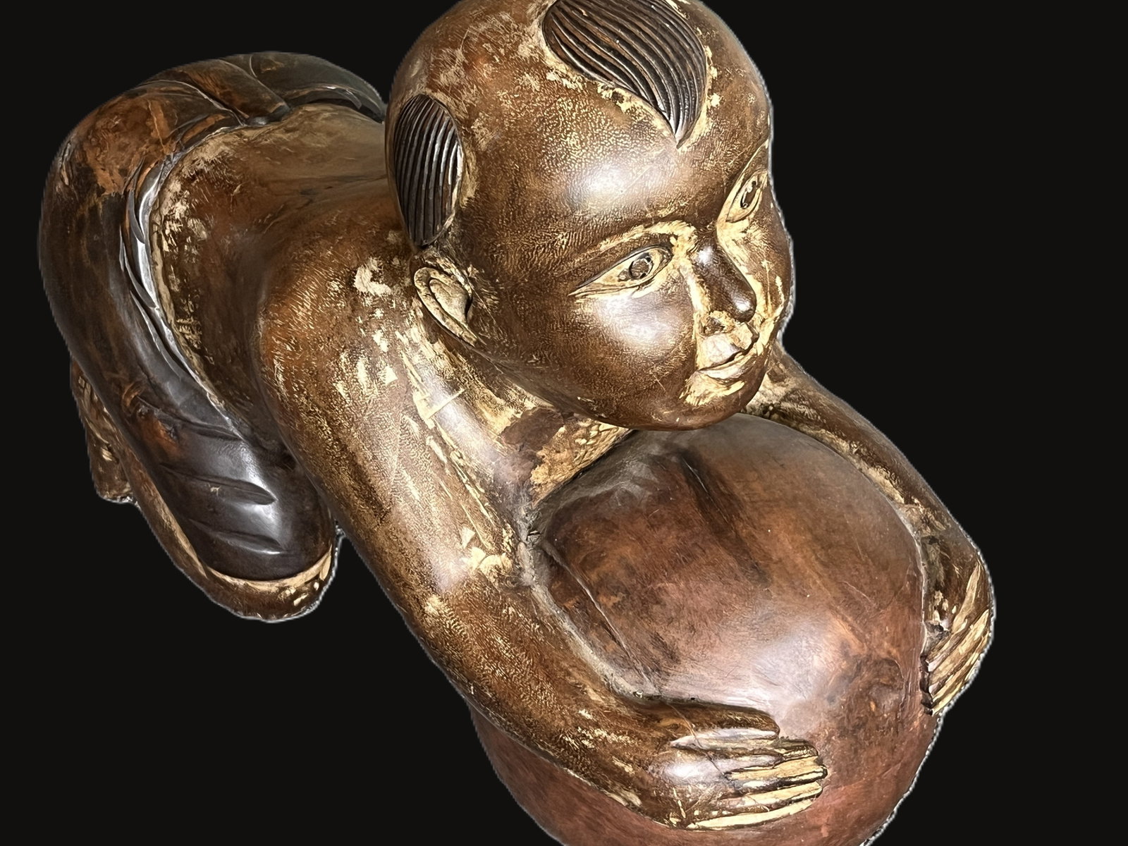 VTG Carved Wood “Opium Baby” Figure: Finely carved wooden figure of a child in a crawling pose, clutching a large ball. The sculpture exhibits smooth contours and expressive facial detailing, with remnants of gilt and dark lacquer finish