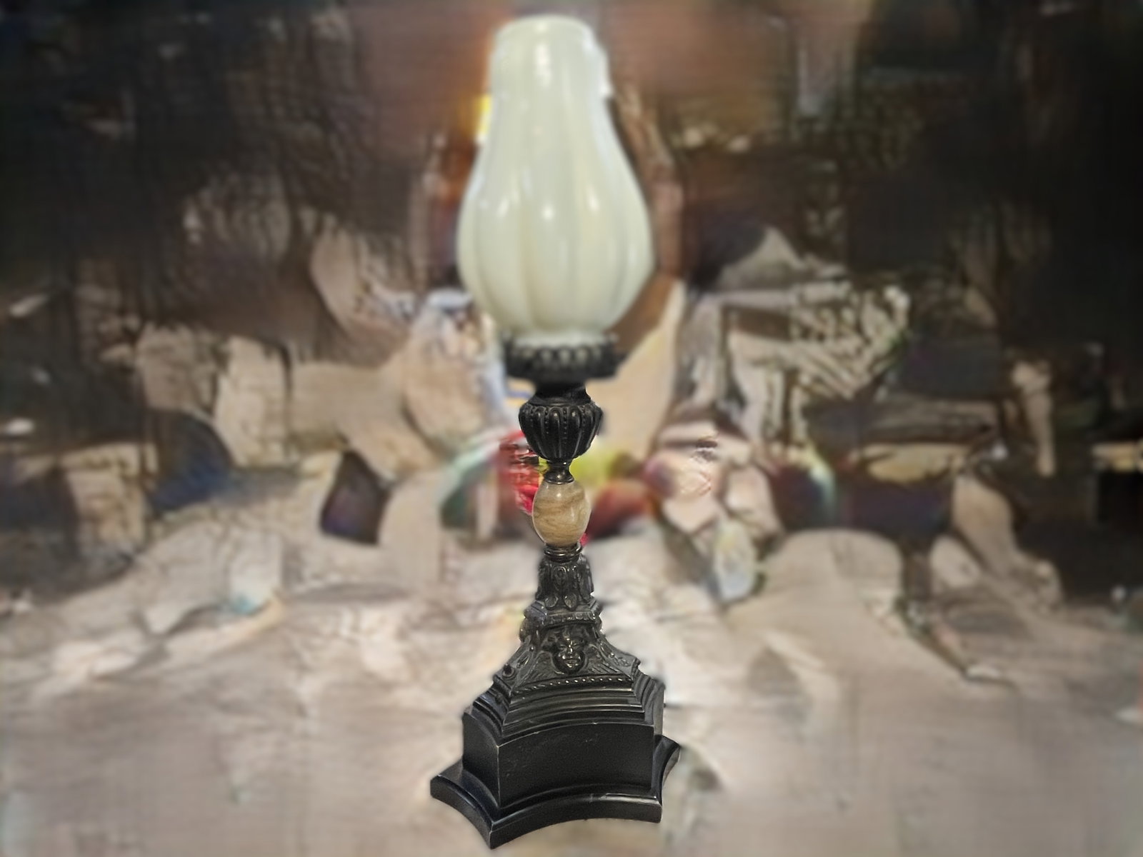 Neoclassical Style Cherub Table Lamp with Milk Glass Globe, 25"H: Decorative Neoclassical-style table lamp featuring an ornate cast metal base with winged cherub (putti) faces, foliate decoration, and a faux marble accent column. The lamp is fitted with a molded whi