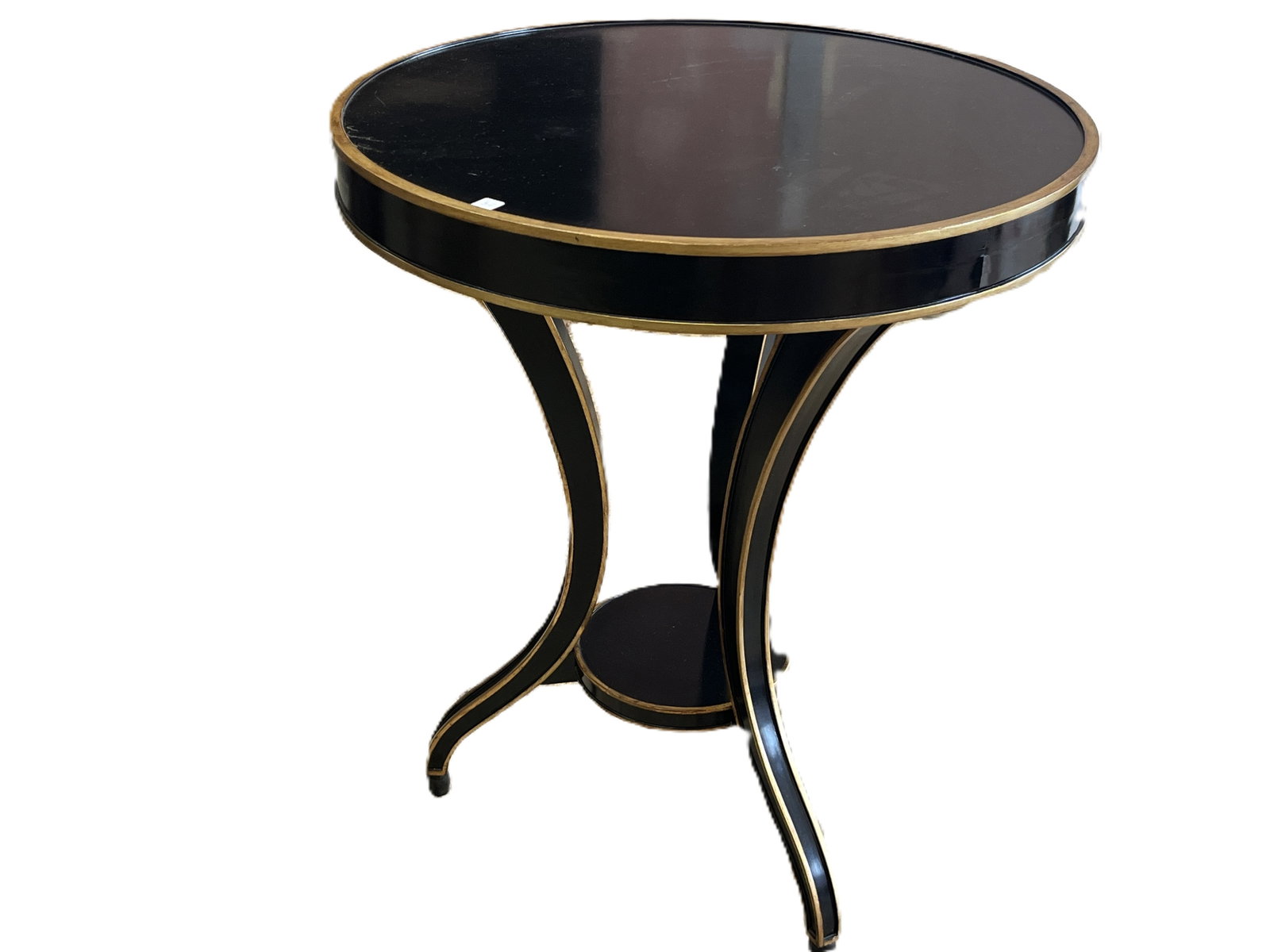 Round Black and Gold Accent Table, 29"H x 24"Dia: Art Deco Revival/Hollywood Regency Elegant round accent table featuring a lustrous black lacquer finish with gilt trim along the top edge, legs, and base. Supported by three gracefully curved legs joi
