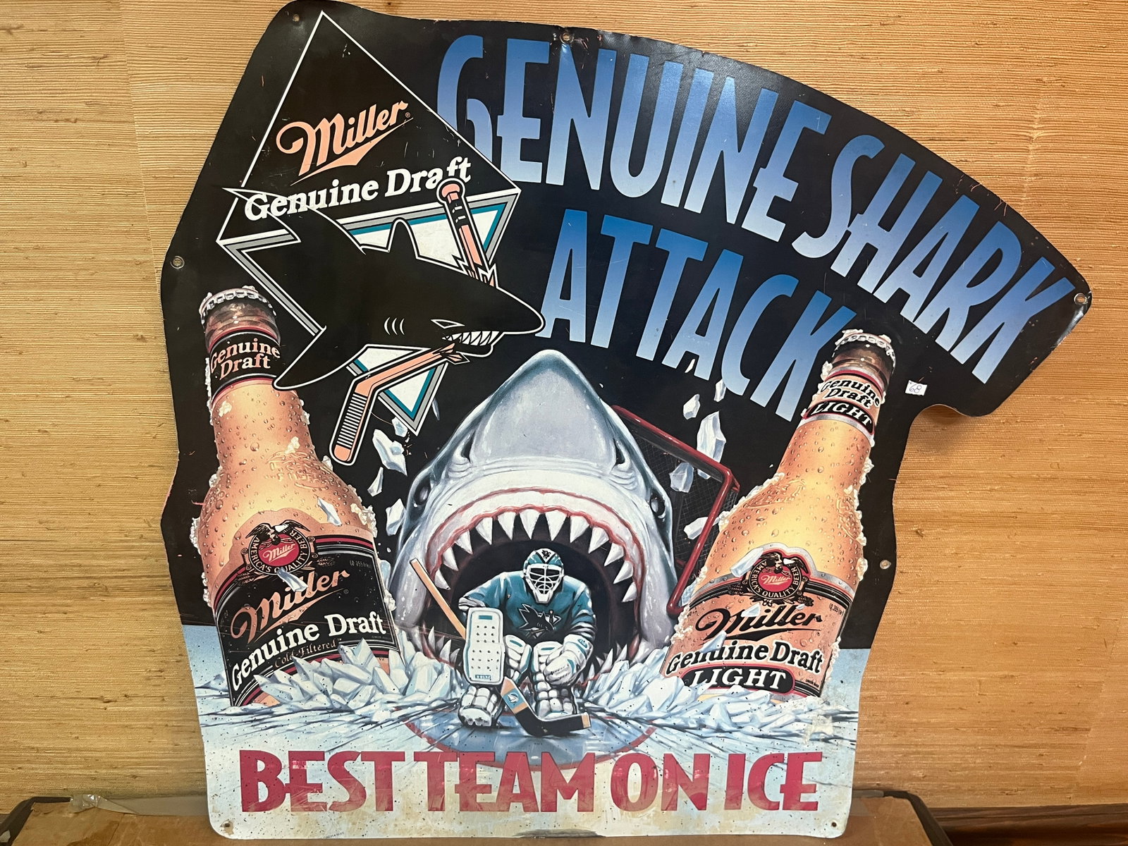 Vintage Miller Genuine Draft "Genuine Shark Attack" Embossed Metal Advertising Sign, 29 x 31 In.: Vintage Miller Genuine Draft embossed metal advertising sign featuring the popular "Genuine Shark Attack ? Best Team on Ice" hockey-themed design. The die-cut sign depicts a great white shark with an 
