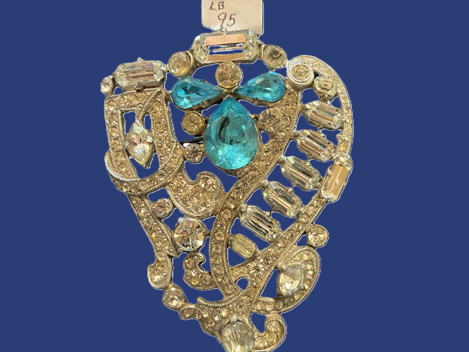 Vintage Gold-Tone Rhinestone Brooch with Aqua and Clear Stones: VTG Brooch, 3.25x2/75. A sparkling vintage brooch featuring an ornate openwork gold tone setting embellished with clear baguette and round rhinestones, accented by three vivid aqua stones two oval and
