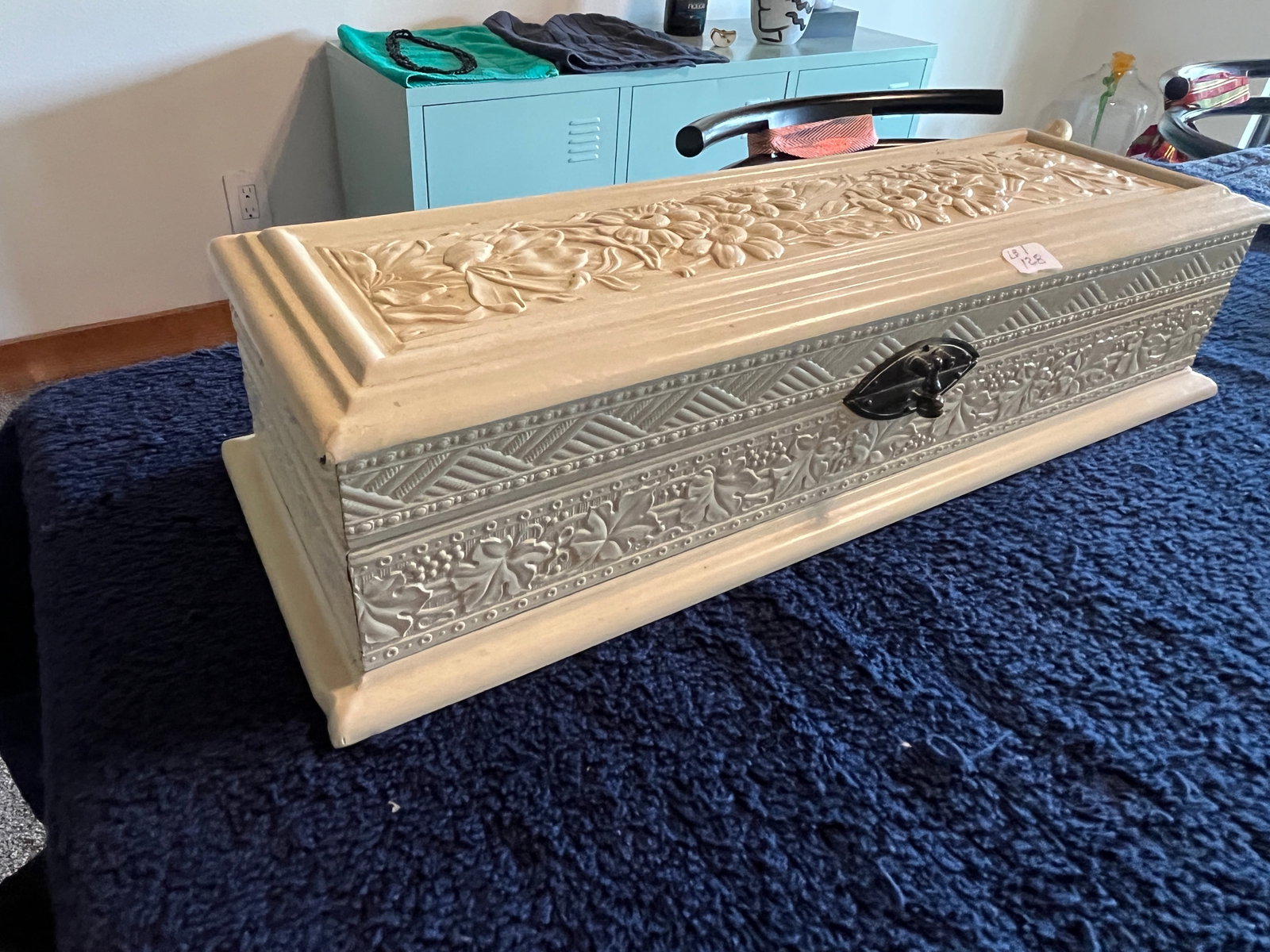 Vintage Embossed Jewelry Casket / Jewelry Box, 3.25h x 13.5w x 4.75d: A finely detailed rectangular jewelry chest featuring raised floral and geometric designs across the lid and sides, accented by a polished metal latch. The interior is lined in ruched satin with a war