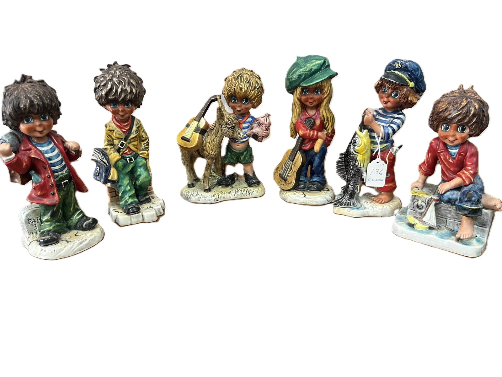Set of Six Vintage Goebel Children in Paris Figurines (Tallest 9inH): Charming mid 20th century collection of six hand-painted Goebel porcelain figurines depicting whimsical children in colorful attire, each engaged in playful or musical scenes. Produced circa 1960s 197