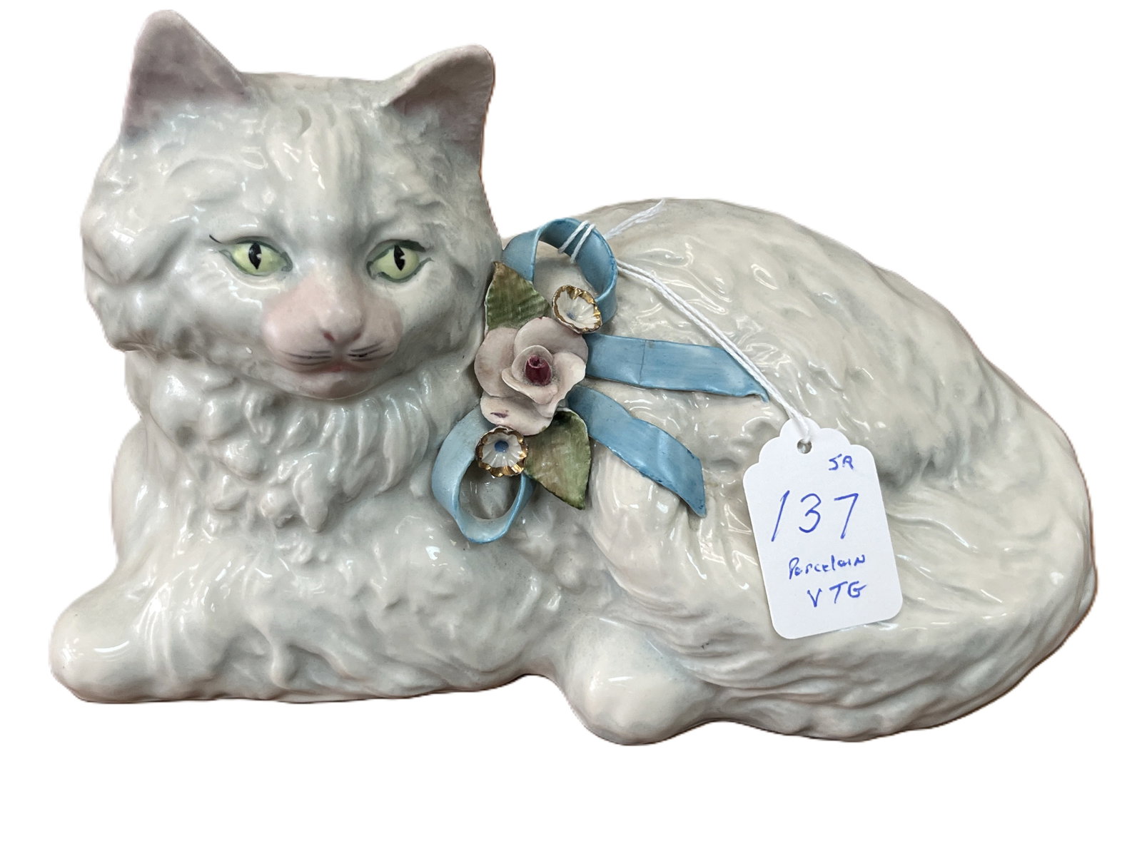 Vintage Cordey Porcelain Cat Figurine with Floral Ribbon, 6x10x4.5: Charming mid?20th?century Cordey porcelain sculpture of a reclining long?haired cat, finely detailed with textured fur and hand?painted features. The cat wears a delicate blue ribbon adorned with appl
