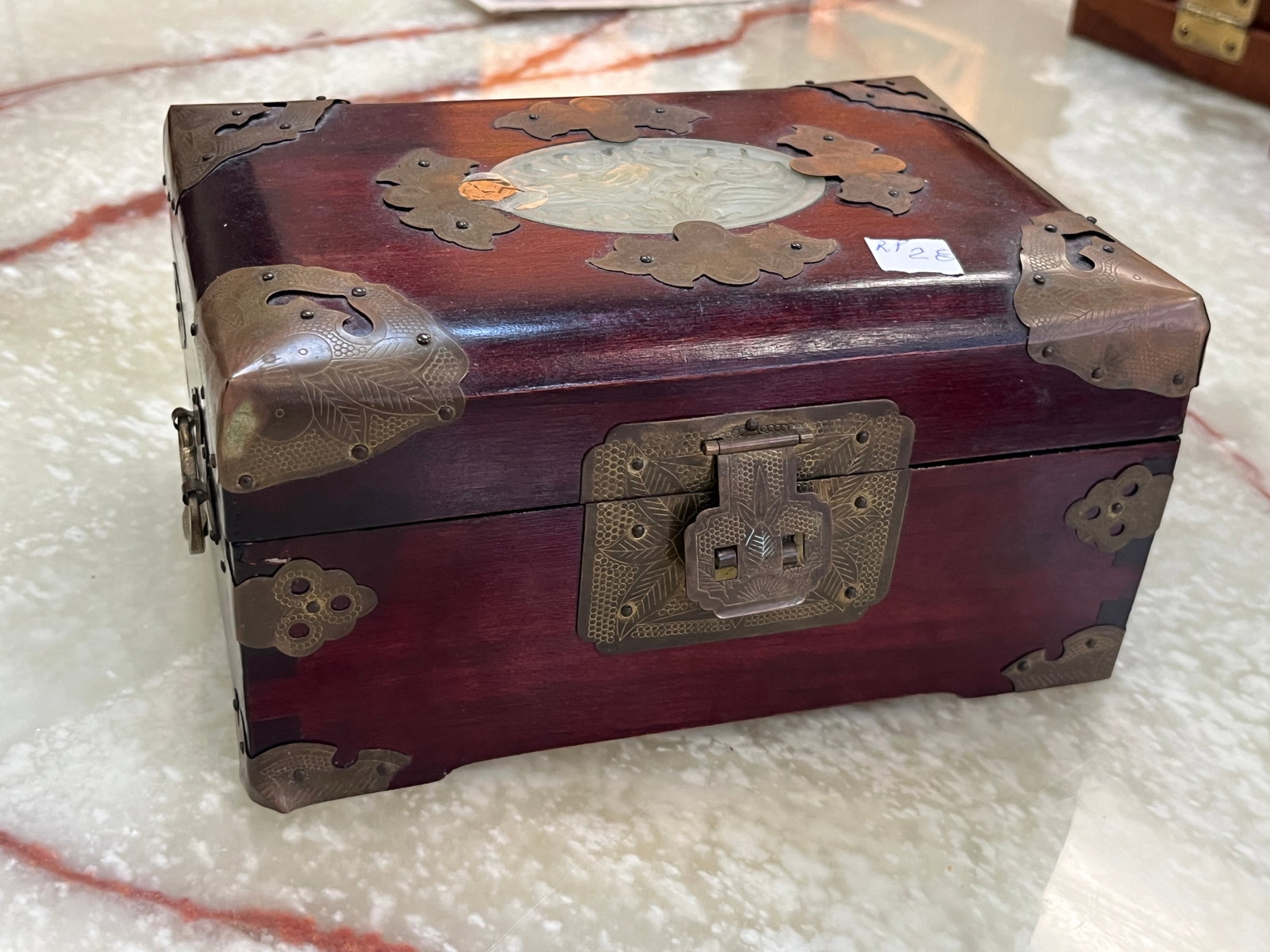 Chinese Rosewood Jewelry Chest with Jade Medallion & Brass Mounts, 4x8x5.5: A finely crafted Chinese rosewood jewelry chest, featuring ornate brass corner and edge mounts with engraved floral motifs and a central carved jade medallion inset on the lid. The interior is lined i
