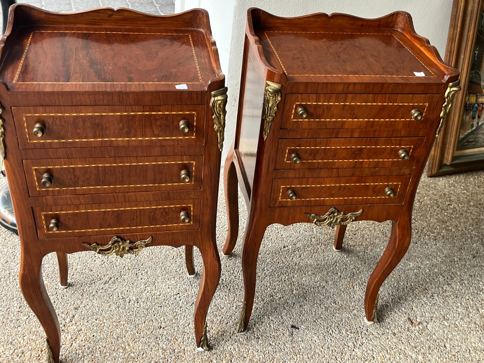 Pair of Louis XV Style Marquetry Walnut Bedside Chests, 27.5"H x 14.5"W x 11"D: Elegant matched pair of Louis XV-style bedside chests or petite commodes crafted with beautifully figured walnut veneers accented by contrasting marquetry string inlay. Each cabinet features three dov