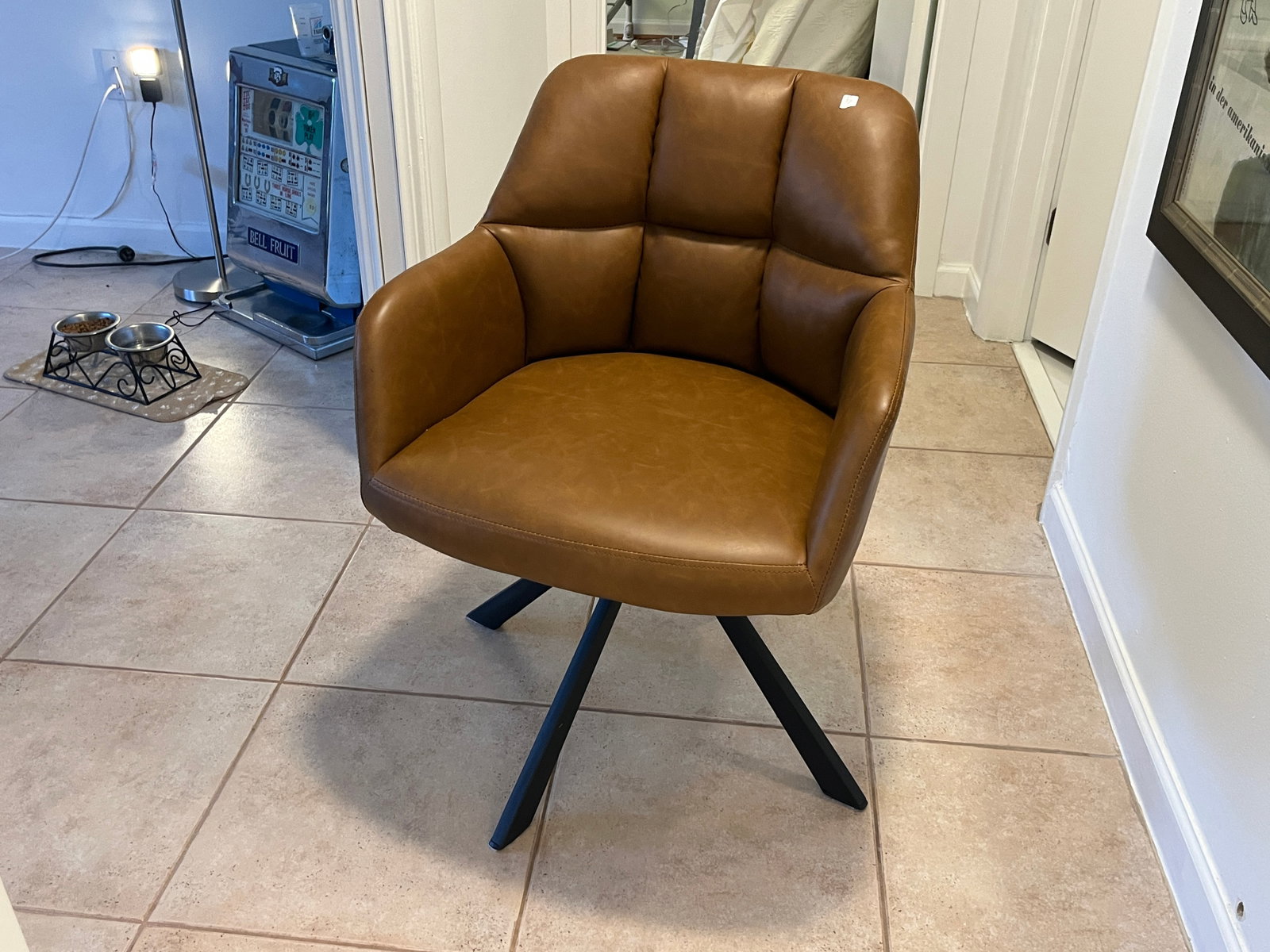 Contemporary Camel Brown Faux Leather Swivel Accent Chair, 32"H ?26"W ?24"D: Stylish modern swivel accent chair upholstered in camel?brown faux leather with channel?stitched cushioning and integrated curved arms. Supported by a black powder?coated metal four?leg base, offering