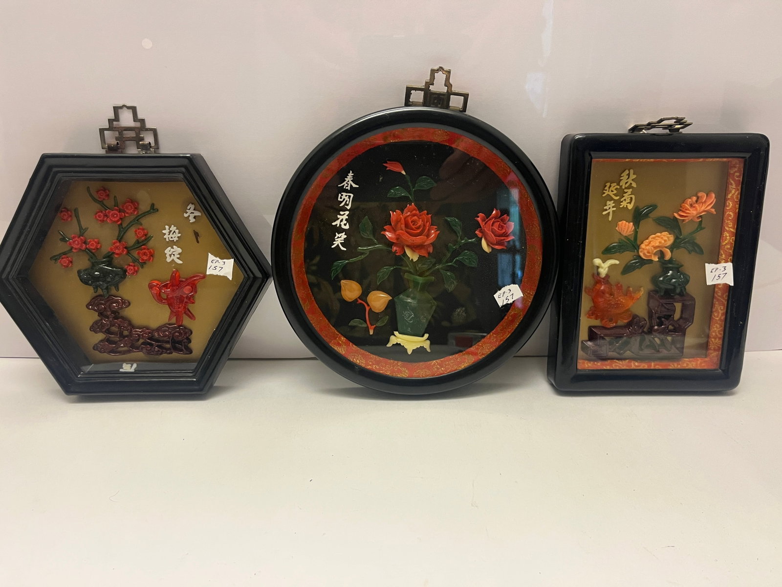 Set of Three Chinese Reverse Glass Floral Panels Seasonal Motifs. Round panel: 7.5"dia.: A charming trio of Chinese reverse glass floral panels representing the seasons plum blossom for winter, rose for spring, and chrysanthemum for autumn. Each feature finely molded hardstone and resin f