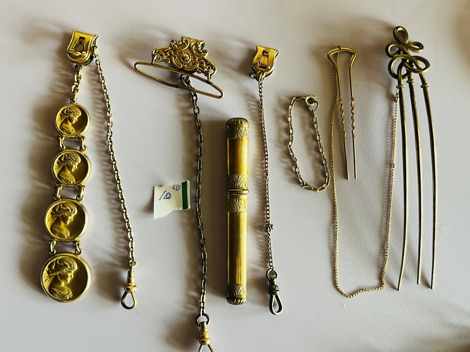 Bag Lot of Vintage Costume Jewelry & Accessories: Assorted bag lot of vintage costume jewelry and accessories featuring a variety of gold-tone pieces. Includes a distinctive four-medallion classical female profile/cameo-style watch chain or fob, seve