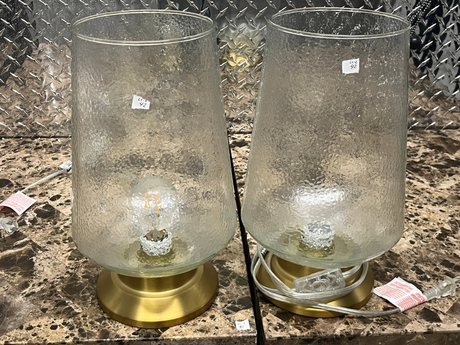 Pair Contemporary Hammered Glass & Brass-Tone Table Lamps, 14"H: Pair of contemporary accent lamps featuring tall clear hammered/textured glass shades or bodies with an attractive hand-worked appearance. Each rests on a round brushed brass-tone metal base and is fi