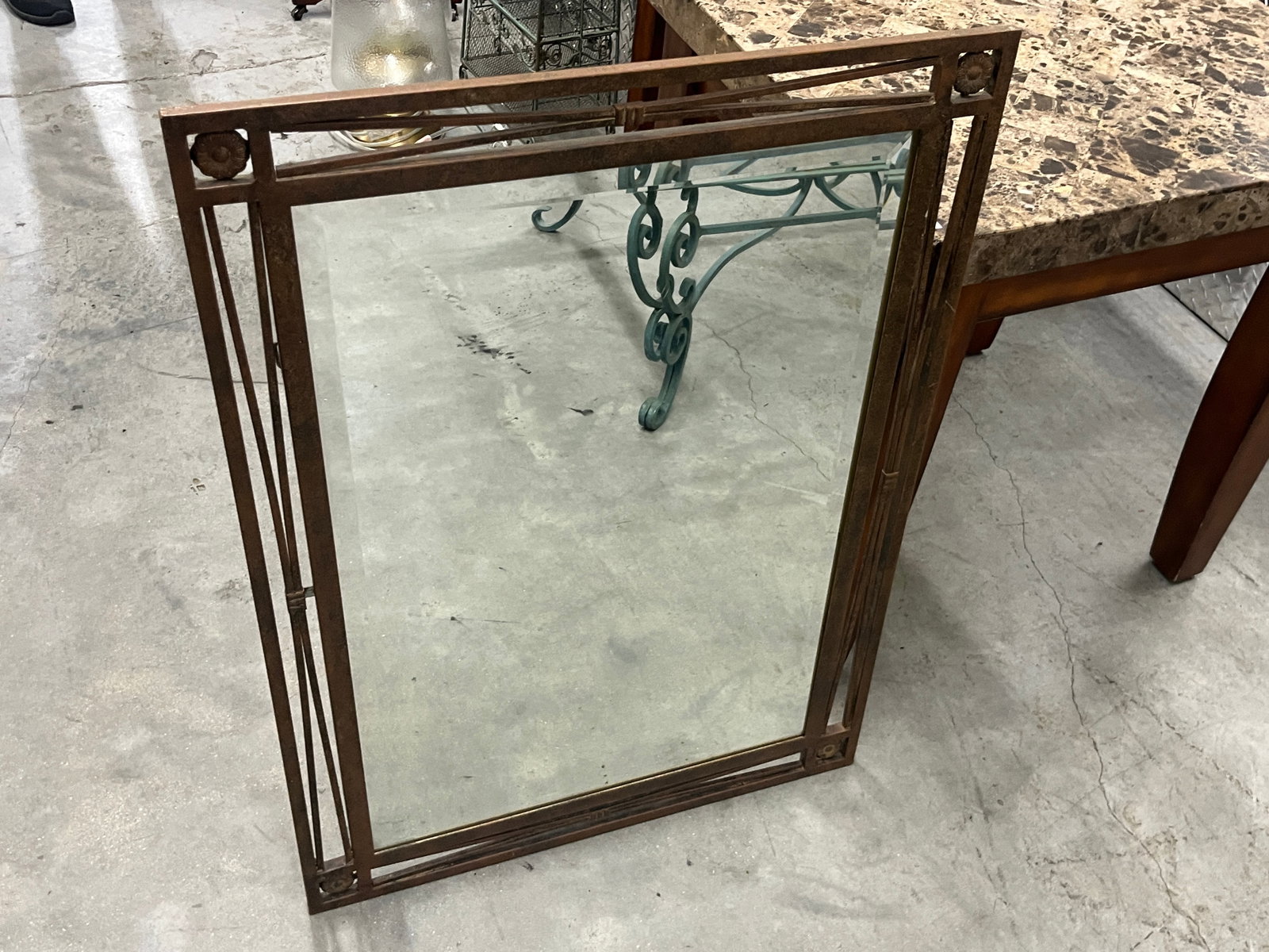 Rustic Antiqued Metal Beveled Wall Mirror w/ Rosette Accents, 31" x 23": Decorative rectangular wall mirror featuring a rustic antiqued metal frame with an open geometric architectural design. The frame is accented with raised floral rosettes at the corners, linear detaili