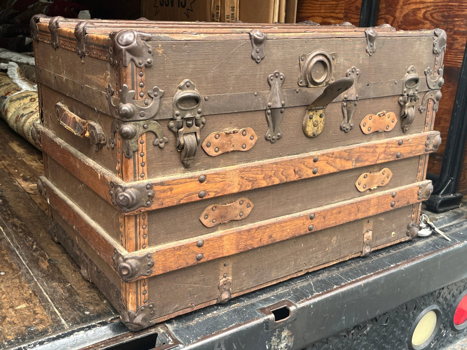 Antique W.F. Livingston Charleston SC Wood Slat Steamer Trunk, 21"H x 31"W x 17"D: Constructed with a canvas-covered body, hardwood reinforcing slats, extensive riveted metal banding, decorative corner and edge protectors, multiple latches and period lock hardware. The sides retain 