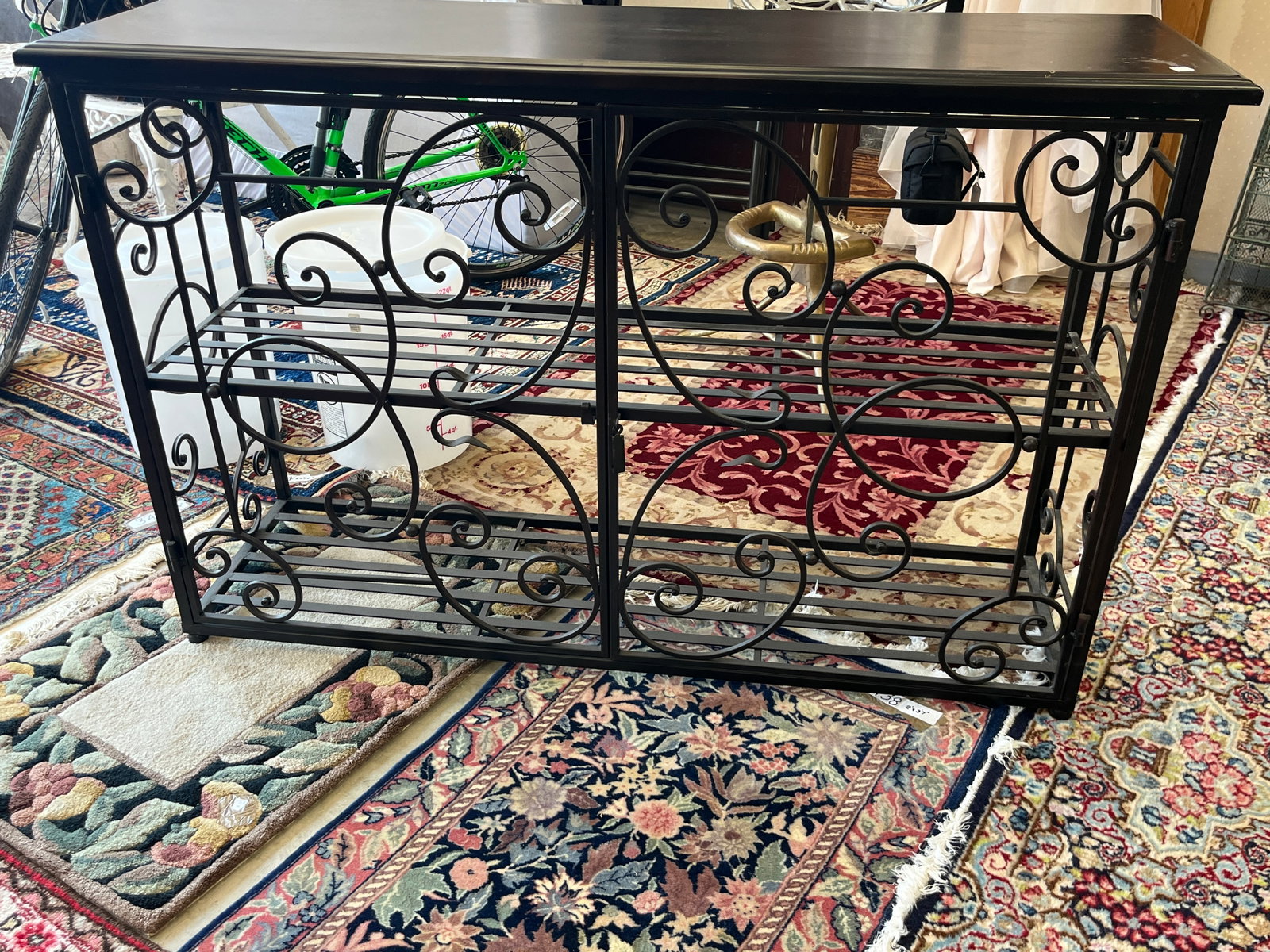 Black Metal Scrollwork Console Table / TV Stand w/ Shelf ? 33" H x 50.5" W x 15.5" D: Decorative black metal console table or TV stand featuring an open wrought-iron style frame with extensive scrolling and curving metalwork throughout the front and sides. Features a substantial rectan