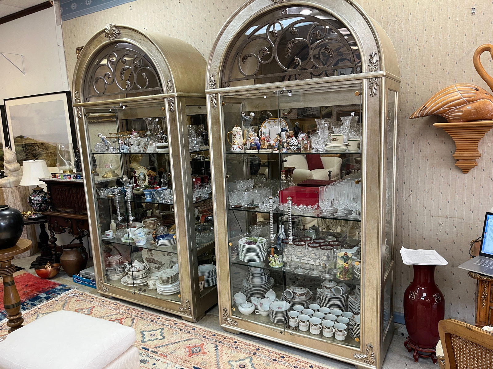 Elegant VTG Henredon Lighted Display Curio Cabinet w/ Glass Shelves ? 93" H x 46" W x 21" D: Elegant vintage Henredon lighted display/curio cabinet featuring a tall architectural form with an impressive arched bonnet top and decorative openwork scroll-and-leaf design. Finished in a softly ant
