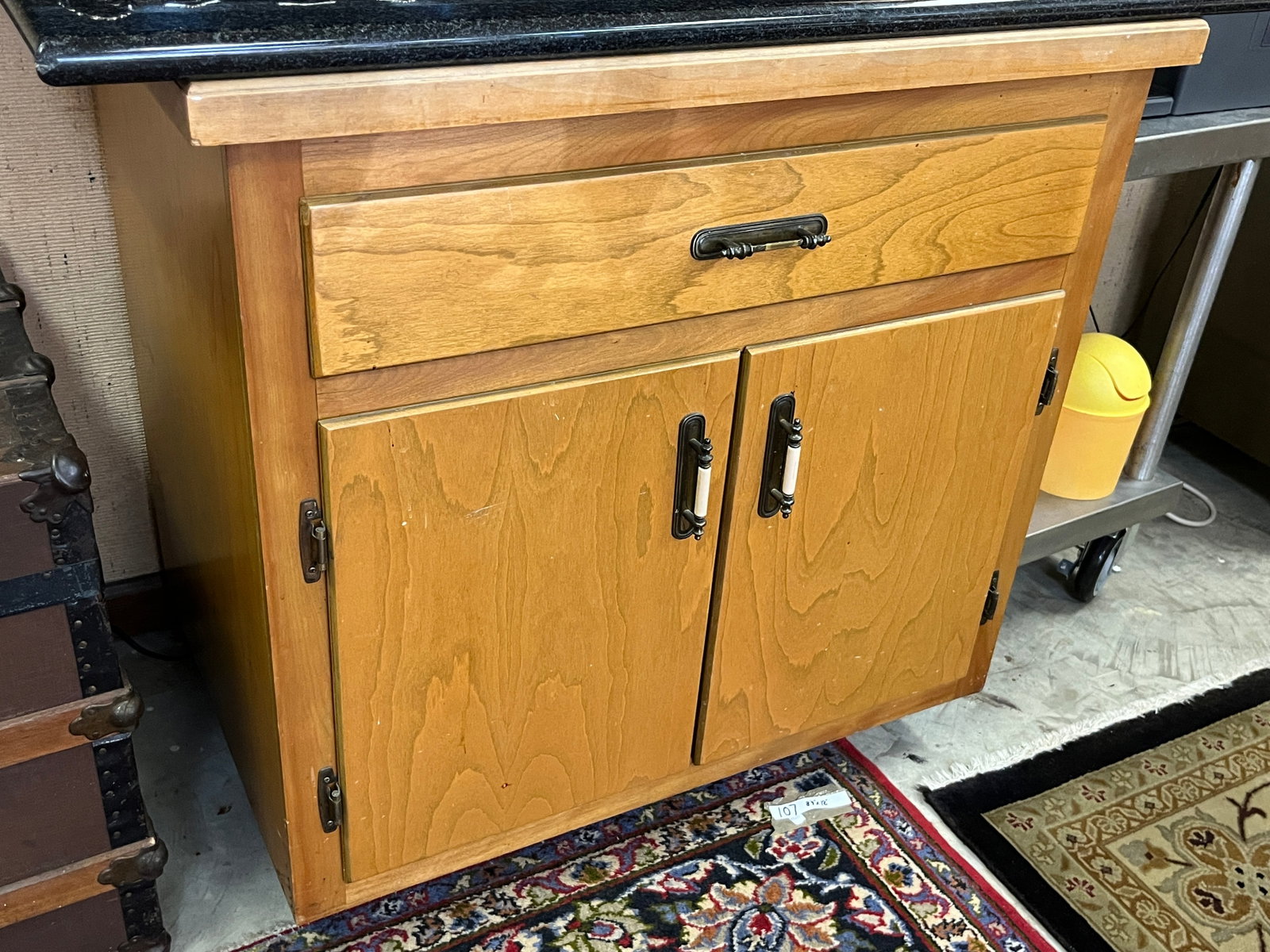 Solid Wood Cabinet with Optional Black Granite Top (35"?H???36"?W???25"?D): Solid wood cabinet featuring one upper drawer and double lower doors with decorative metal handles. Warm natural finish with visible grain pattern. The cabinet itself is offered for sale; however, the