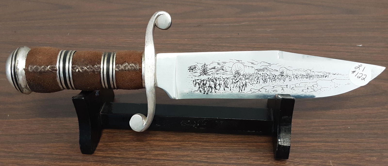 Fantastic custom made western Bowie knife: Fantastic custom made western Bowie knife. A beautiful edged blade featuring a wagon train. A leather wrapped handle. Note the blade is stamped F/M. Overall length 12 inches.