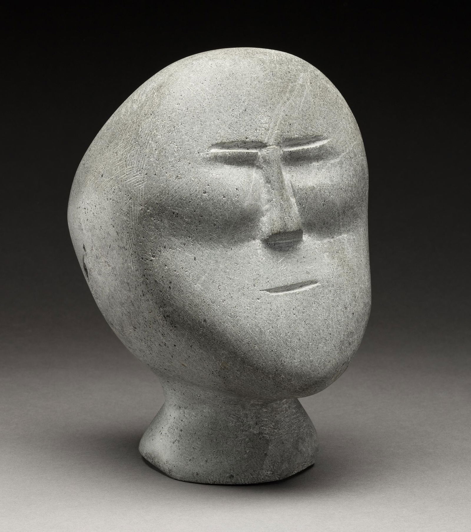 JOHN TIKTAK, Inuit, Head, c. 1964-5: JOHN TIKTAK, R.C.A. (1916-1981) KANGIQLINIQ (RANKIN INLET) Head,c. 1964-5 stone, 8 x 5 x 5.75 in (20.3 x 12.7 x 14.6 cm) unsigned. Provenance Marion Scott Gallery, Vancouver, BC; Acqui